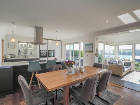 Dining area with table and six chairs, conservatory area with sea view