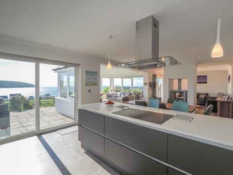 Kitchen and living and dining area with double doors leading to patio, sea view