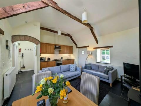Open plan kitchen/lounge/dining area: well equipped kitchen, two sofas, standard lamp, wood burner, TV on unit, dining table