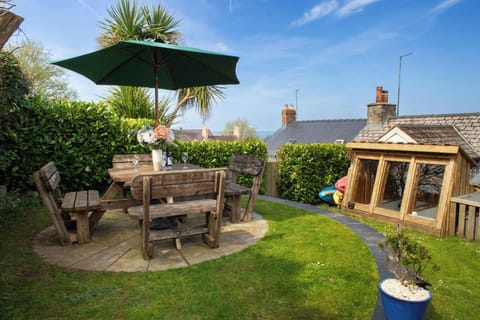 Garden with wooden table and chairs and parasol