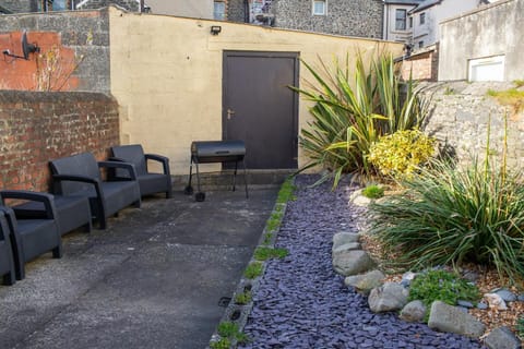Court yard garden with patio chairs and BBQ