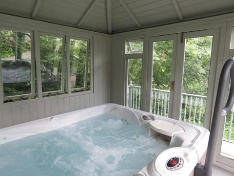 Hot tub in covered conservatory building with garden views