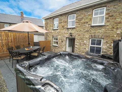 Hot tub with parasol, patio table, and 6 chairs