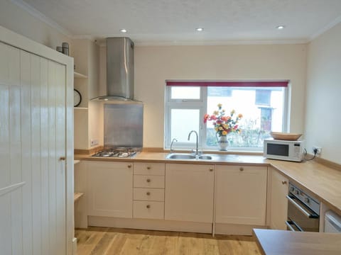 Fitted kitchen in Ffynnonddewi with hob, oven microwave and window