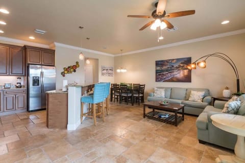 Open-concept living and dining area with modern kitchen and coastal decor.
