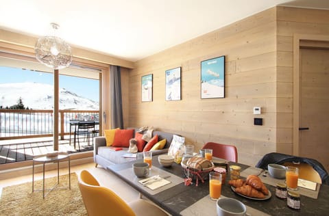 Bright and inviting living space with a cosy setup and stunning mountain views, perfect for unwinding after a day of adventure
