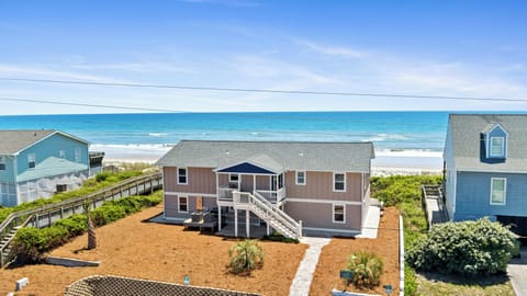 Spacious beachfront property featuring direct ocean access and coastal landscaping with neighboring homes along the shoreline.