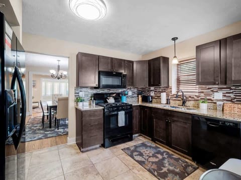 Modern kitchen  with granite countertops, stylish backsplash, and full-size appliances. Perfect for cooking up your favorite meals or enjoying morning coffee ☕.