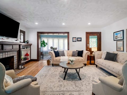 Relax in a bright living room w/ comfy seating, TV & natural light streaming through wide windows