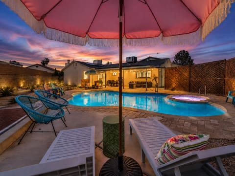 Resort-style backyard with pool, spa, lounge seating, and sunset views