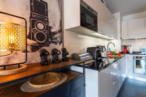 Elegant kitchen with modern appliances, tasteful decor, and artistic details creating a unique atmosphere.