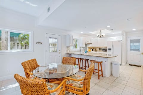 Bright dining area with woven chairs and open kitchen for easy gatherings.