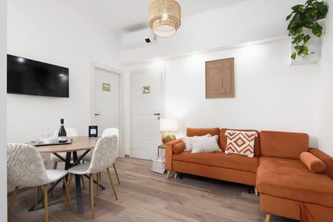 bright living room with smart tv and dining table 