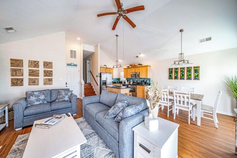 Airy open-concept living area with vaulted ceilings and coastal décor