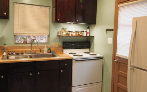 Full kitchen with pots & pans, eating utensils, plates. glasses, cooking oil etc