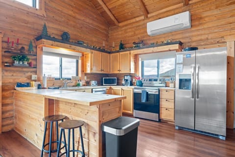 Inviting wooden kitchen with island seating, modern amenities, and cabin charm.