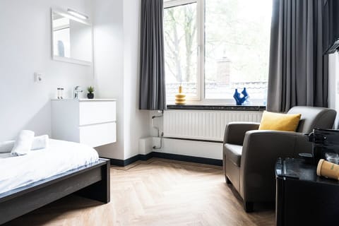Omarm de schoonheid van eenvoud in onze minimalistische slaapkamer, waar kleine ruimte grote stijl ontmoet—de perfecte moderne retraite voor gasten die de Efteling of Safaripark Beekse Bergen bezoeken.