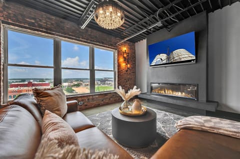 Immerse yourself in style with this living room, where stunning hardwood accents beautifully complement plush gray furniture and a chic camel leather sofa, creating a warm and inviting atmosphere.