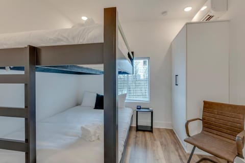The stacked sleeping space with clean white frames and natural light is ready for a group stay.