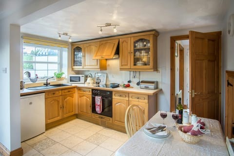 Fitted kitchen with cooker, microwave, kettle and toaster, fridge, dining table and chairs