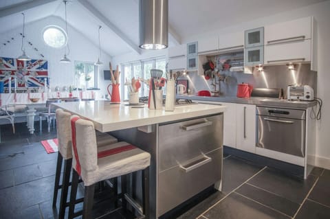 Large island unit with gas hob and extractor hood. Two bar stools