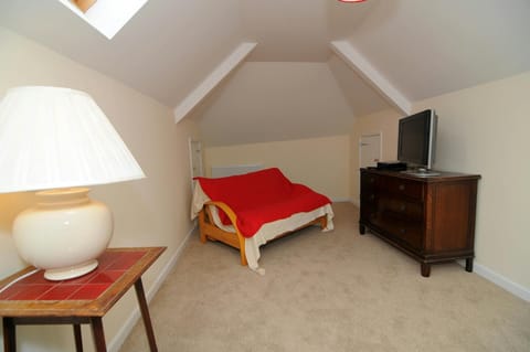 Second living room with sofa-bed, large drawer unit with TV, small table with lamp