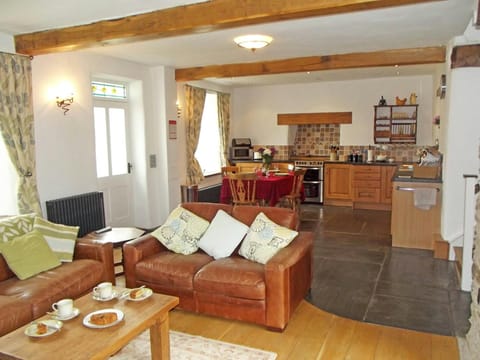 Open plan living room/kitchen: sofas and coffee table, fitted kitchen with dining table and four chairs