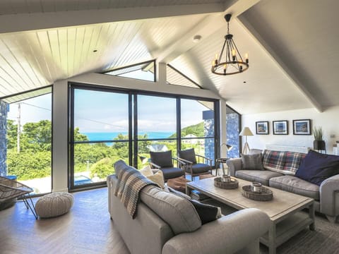 Lounge with large pane windows looking out into the garden.