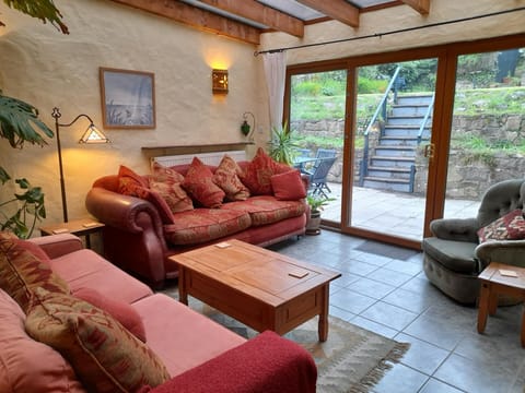 Second lounge: two sofas, armchair, coffee table, patio doors leading to outside