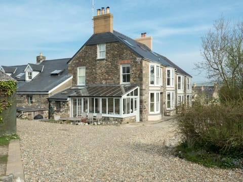 Gravel driveway and outside of Min y Mor, with conservatory