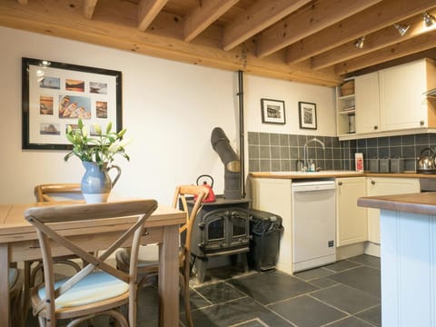 Dining table, wood burning stove and kitchen cabinets