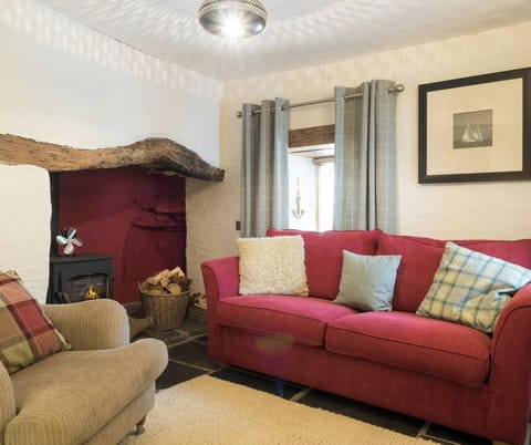 Lounge with sofa, armchair and fireplace with wood burner