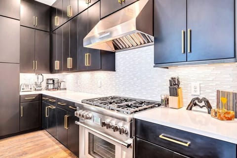 Explore this elegant Nashville kitchen, perfect for culinary adventures and gatherings. With sleek black cabinetry and premium finishes, it's ideal for brunches, feasts, or lively bachelorette parties. Enjoy a sophisticated ambiance for a memorable getaway.