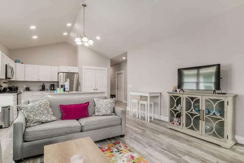 Full living room, with flat screen TV. Perfect for family vacations, or a couples getaway. Couch and loveseat. and living room attached to a kitchen with Island.