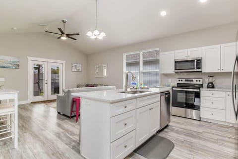 Full living room, with flat screen TV. Perfect for family vacations, or a couples getaway. Couch and loveseat. and living room attached to a kitchen with Island.