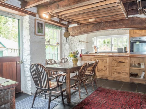 Kitchen with wooden wood beams, dining table an chairs, stable door