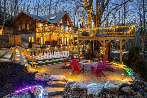Twilight enchantment at a forested cabin retreat aglow with welcoming lights.