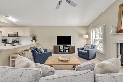 Bright open living room with kitchen and blue sofas