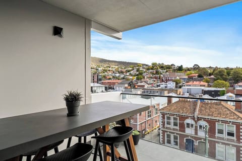 A private patio offers sprawling views of Mount Wellington and a high top table for alfresco meals.