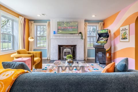 Explore our spacious living area, where vibrant colors meet elegant vibes. This inviting space is equipped with a Smart TV and a nostalgic arcade machine, offering the perfect blend of modern entertainment and a trip down memory lane. Designed for comfort and style, it's an ideal setting for relaxation and fun.