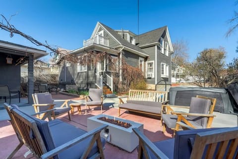 Adirondack chairs ring the fire pit table on the patio—grab a seat, spark a flame, and let conversation linger as the house glows behind you.