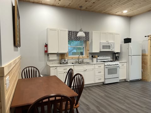 Full kitchen with new appliances and a view past our deck of our beach