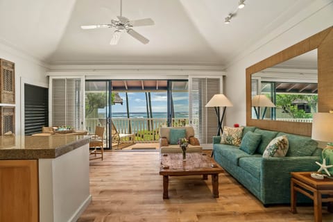 Ocean-view living room with lanai, ceiling fan, and comfy sofa-sip coffee while waves roll 