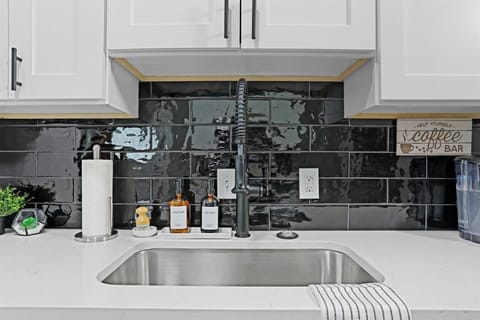 Cook in style with modern fixtures and a chic black tile backsplash!