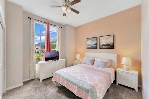 A cheerful bedroom with soft colors, natural light, and a TV for relaxing