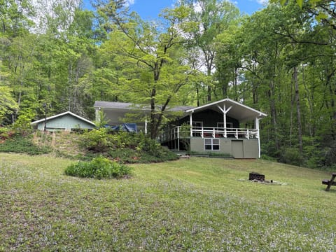 The covered deck looks out over the property.  Fire ring in the foreground. 