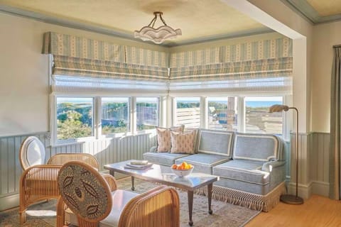 Relax in a sun-drenched sitting room where wraparound windows invite in sweeping views and laid-back coastal charm.