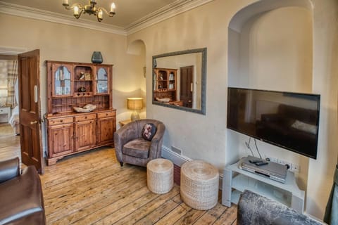Armchairs and stools, wall mounted TV and mirror. Welsh Dresser