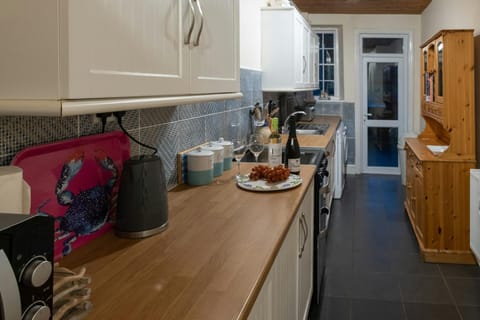 Fitted kitchen, cooker, sink, microwave, kettle, toaster and Welsh dresser