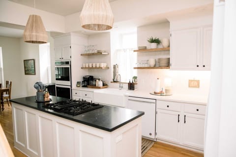 Chef’s kitchen with gas cooktop island, white cabinets, and open shelving—cook, chat and savour every meal together 🍽️👩‍🍳